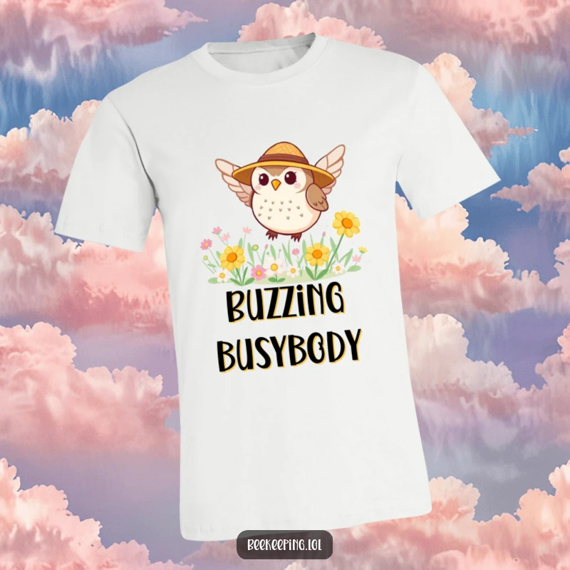 Funny T-shirt featuring a tiny, round owl wearing a straw hat, cheerfully buzzing around a bustling flower patch.